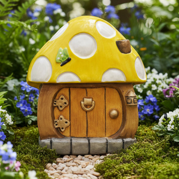 A small mushroom-shaped decorative house figurine with a bright yellow cap, white polka dots, a wooden-textured door, and a grey stone base,