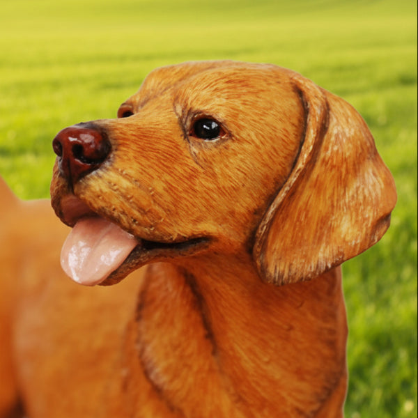 A lifelike figurine of a golden retriever dog standing on a light-colored oval base