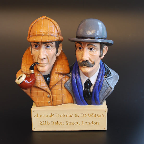 Busts of Sherlock Holmes and Dr. Watson on a wooden base with text.
