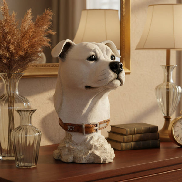 A sculpted dog bust sculpture of a white dog wearing a brown leather collar, mounted on a textured stone-like base