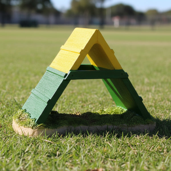 A yellow and green A-frame dog agility trophy with a flat base, steep incline, and a flat top resembling a dog agility course.