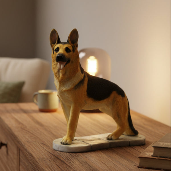 A German Shepherd figurine standing on a small stone-textured base, placed on a wooden table in a warmly lit living room setting.